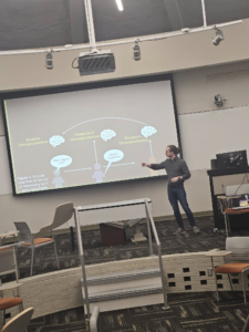 Picture of Wink pointing on his PowerPoint presentation